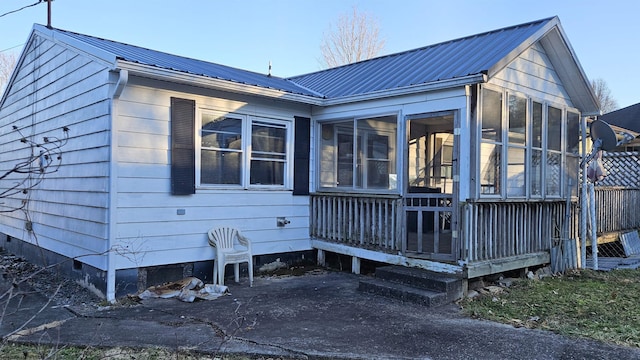 exterior space featuring a sunroom, crawl space, and metal roof