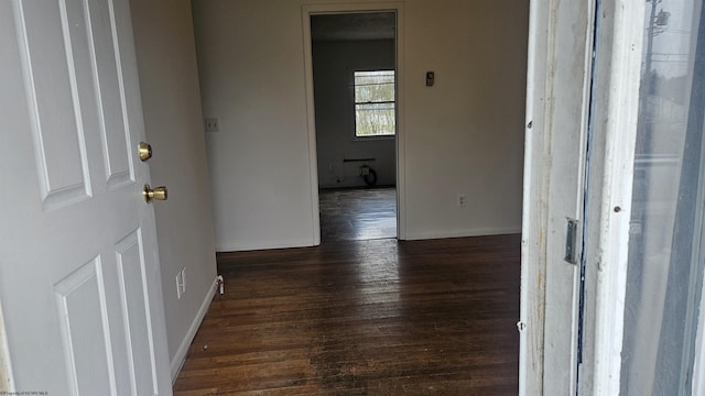 hall with dark wood-style floors and baseboards