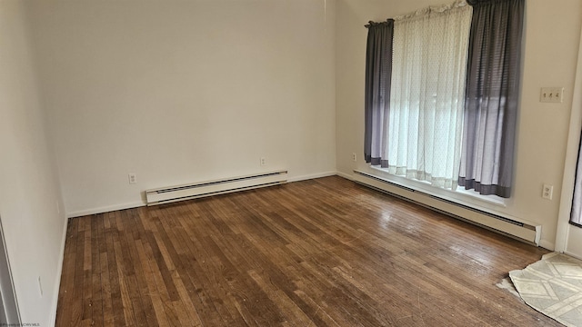 spare room featuring baseboards, a baseboard heating unit, and wood finished floors