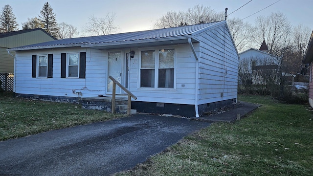 view of front of property featuring crawl space, a front lawn, and metal roof