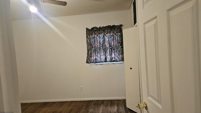 bedroom featuring dark wood-style floors, a textured ceiling, and baseboards