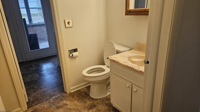 bathroom featuring vanity, toilet, and baseboards