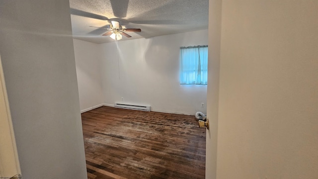 spare room featuring ceiling fan, a textured ceiling, baseboard heating, and dark wood-type flooring