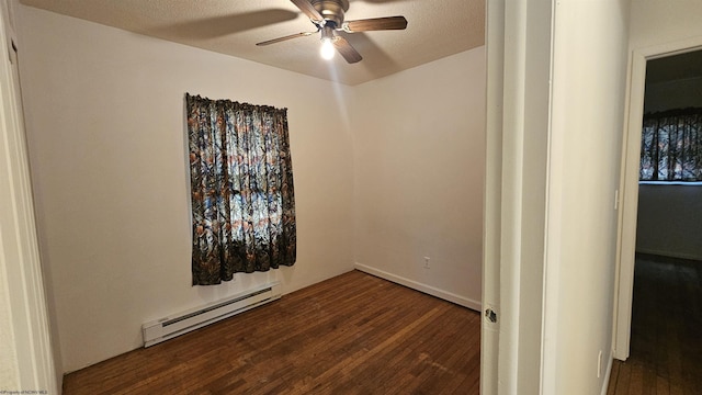 spare room featuring a textured ceiling, a ceiling fan, baseboard heating, and dark wood-style flooring