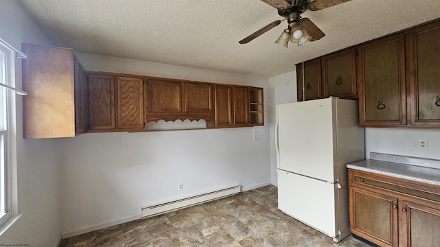 kitchen featuring a ceiling fan, a baseboard radiator, freestanding refrigerator, light countertops, and open shelves