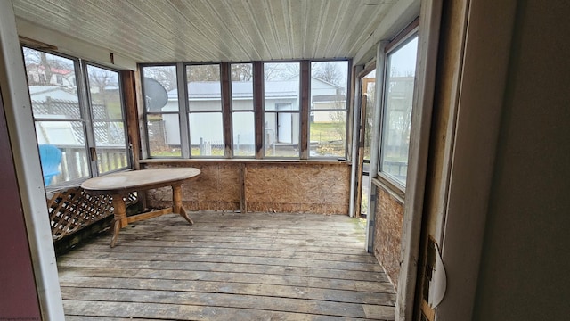 sunroom / solarium featuring a healthy amount of sunlight and wood ceiling