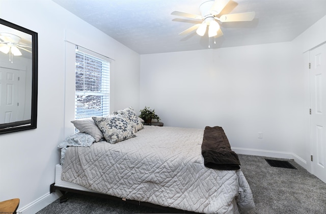 carpeted bedroom featuring a ceiling fan, visible vents, and baseboards