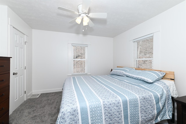 carpeted bedroom featuring a ceiling fan, multiple windows, and baseboards