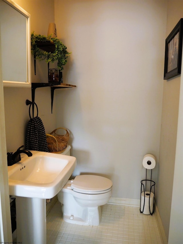 half bathroom with toilet and baseboards