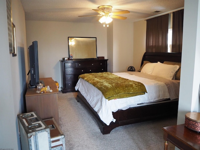 carpeted bedroom featuring visible vents, ceiling fan, and a textured ceiling