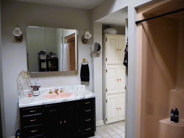 full bathroom with a textured ceiling, curtained shower, tile patterned flooring, and vanity