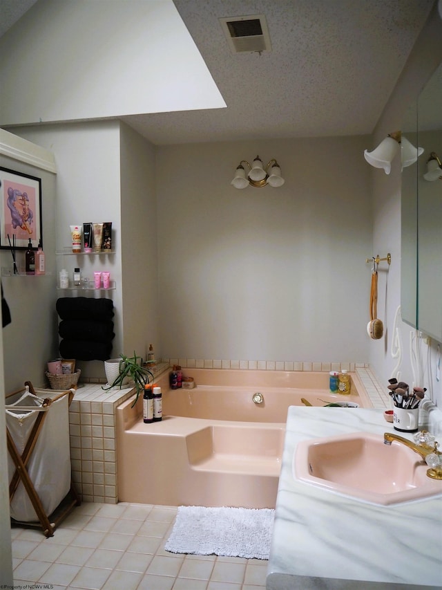 bathroom with a textured ceiling, a garden tub, a sink, visible vents, and tile patterned floors