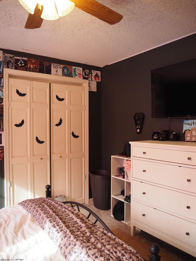 carpeted bedroom featuring ceiling fan, a closet, and a textured ceiling