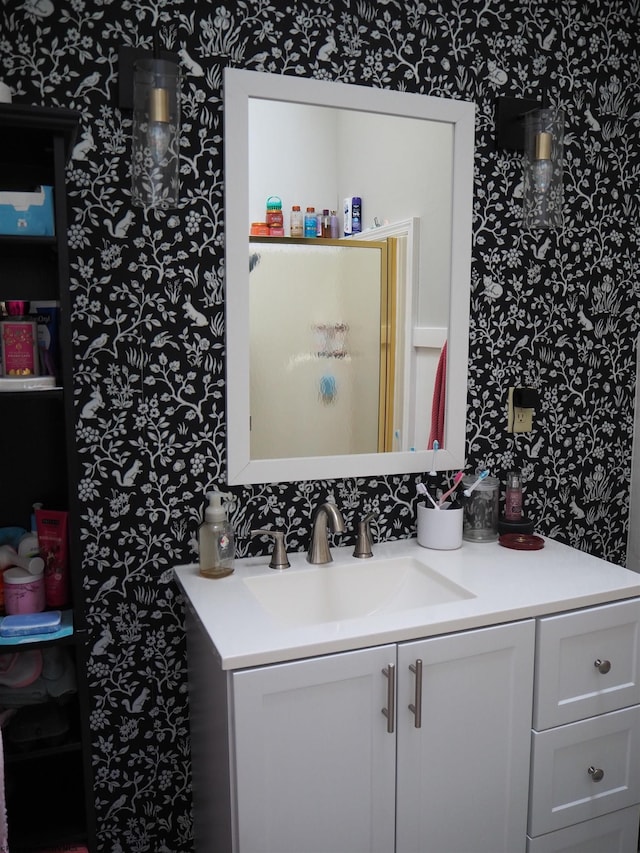 bathroom featuring vanity and wallpapered walls