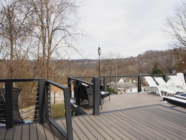 wooden terrace featuring a wooded view