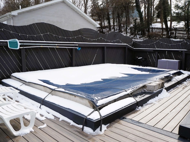 snow covered deck featuring fence