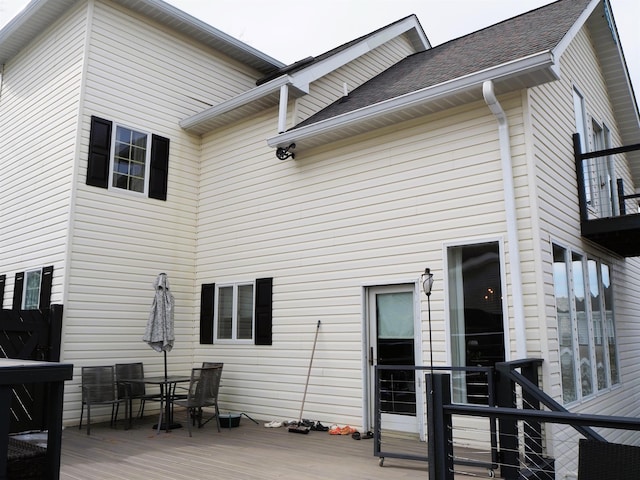 back of house with outdoor dining space, a shingled roof, and a wooden deck