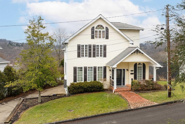 traditional home featuring covered porch and a front lawn