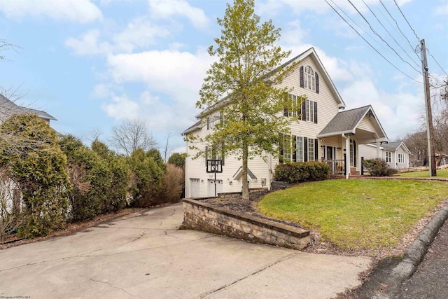 view of property exterior with a garage, covered porch, a lawn, and concrete driveway