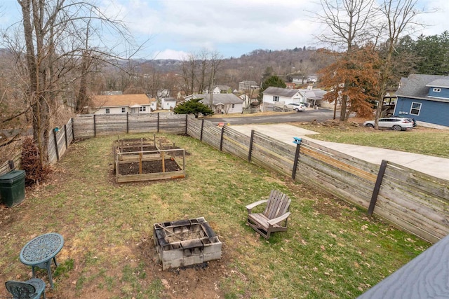 view of yard with fence private yard, a garden, and a residential view