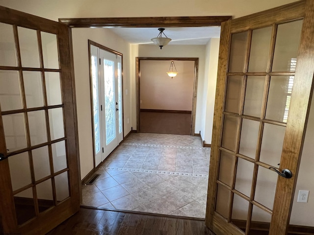 doorway featuring light wood-style flooring and baseboards