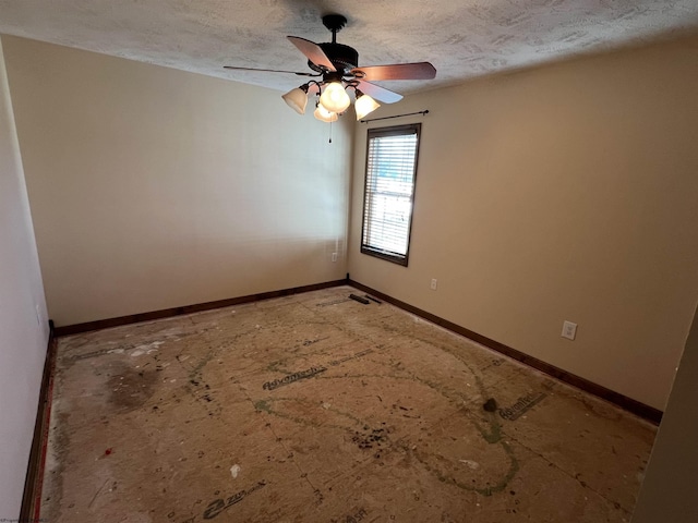 empty room with a ceiling fan, a textured ceiling, and baseboards