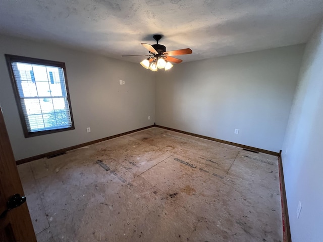 spare room featuring visible vents, a ceiling fan, and baseboards