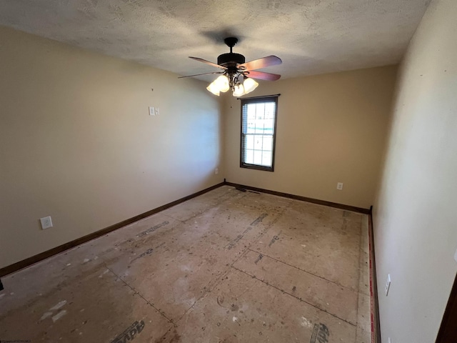 unfurnished room with a ceiling fan, a textured ceiling, and baseboards