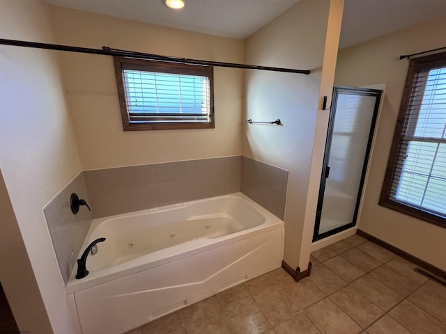 full bath featuring visible vents, a jetted tub, a wealth of natural light, and tile patterned floors