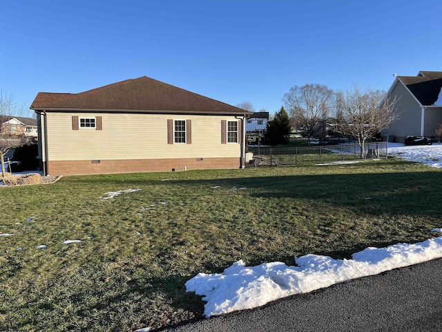 view of side of property with crawl space, a yard, and fence