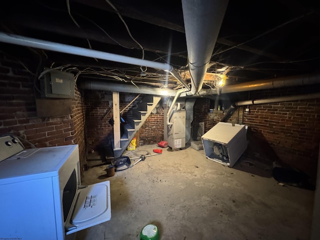 unfinished basement with washer / clothes dryer, electric panel, stairway, and heating unit