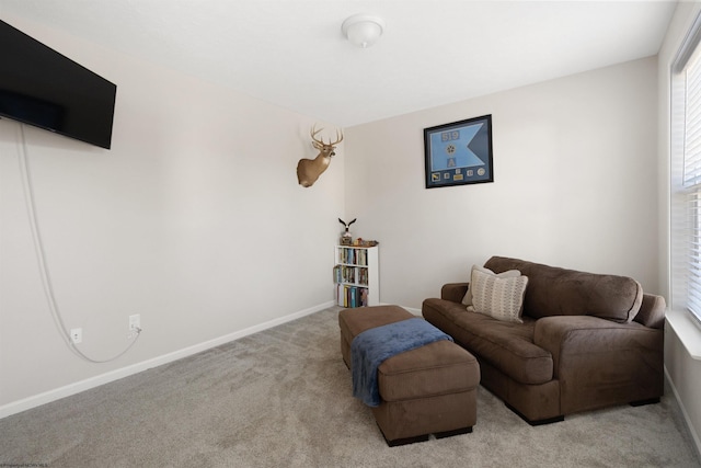 living area with light carpet and baseboards