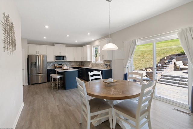 dining area featuring light wood-style floors, baseboards, visible vents, and recessed lighting