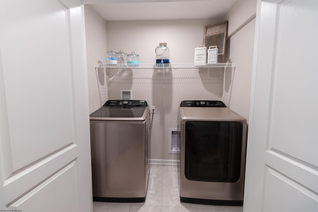 washroom featuring laundry area, independent washer and dryer, and light tile patterned flooring