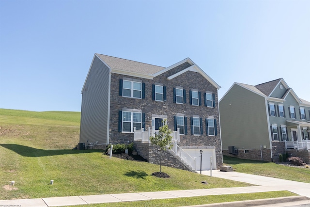 view of front facade with driveway, central AC unit, stairway, and a front yard