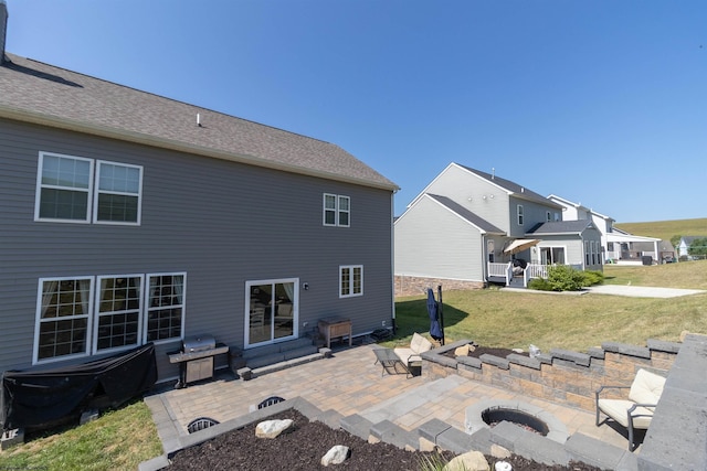 back of property with a residential view, a patio area, and a lawn