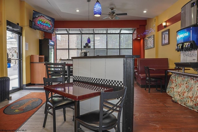 interior space with radiator, ceiling fan, wood finished floors, and recessed lighting