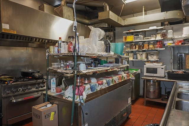 kitchen featuring white microwave, tile patterned floors, and stainless steel stove