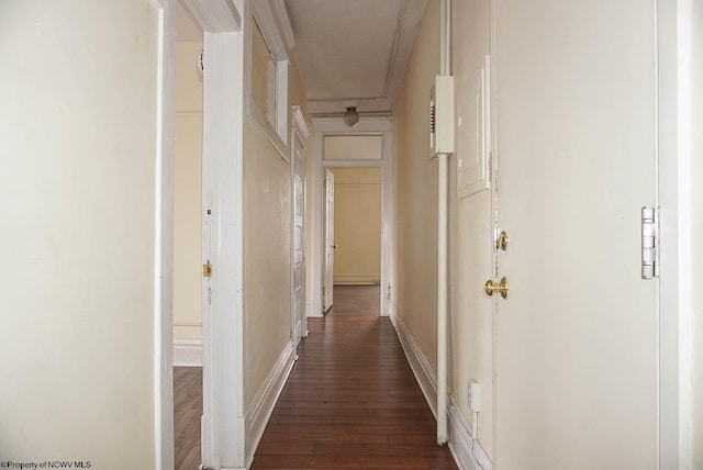 corridor featuring dark wood-style floors and baseboards