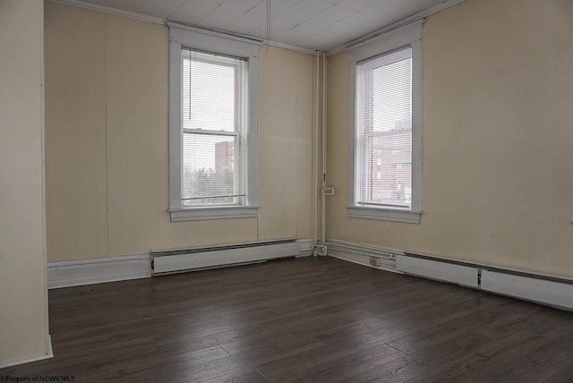 empty room with a wealth of natural light, dark wood-style flooring, and baseboard heating