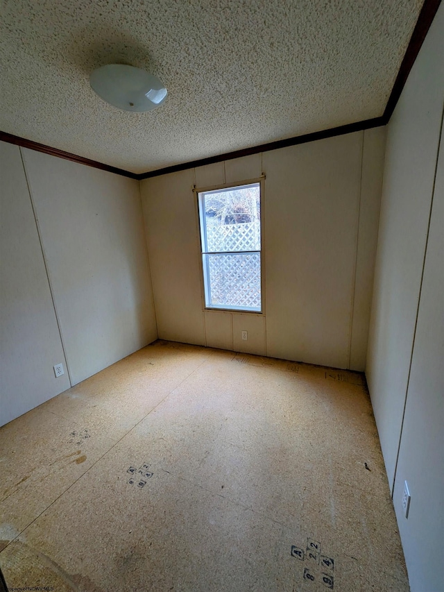 empty room featuring a textured ceiling and crown molding