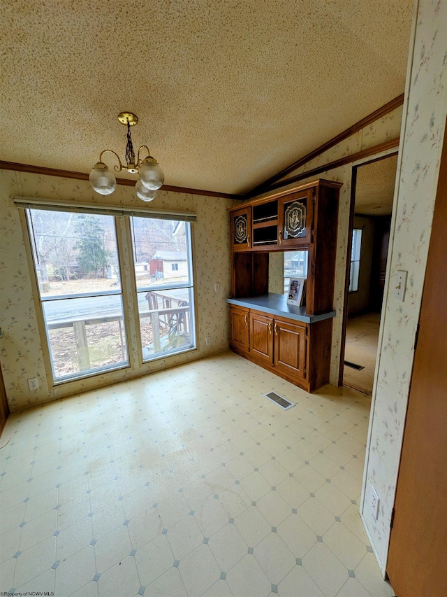 kitchen featuring crown molding, light floors, and wallpapered walls