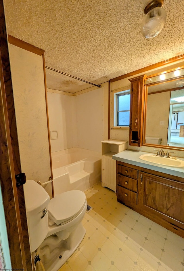 bathroom featuring toilet, vanity, a textured ceiling, and tile patterned floors