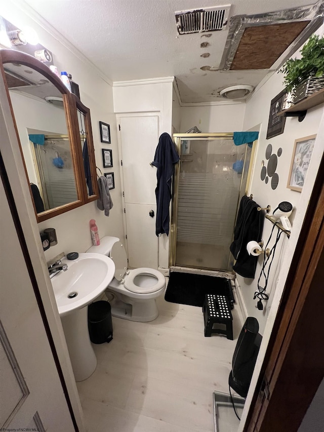 bathroom featuring a stall shower, visible vents, wood finished floors, a textured ceiling, and a sink