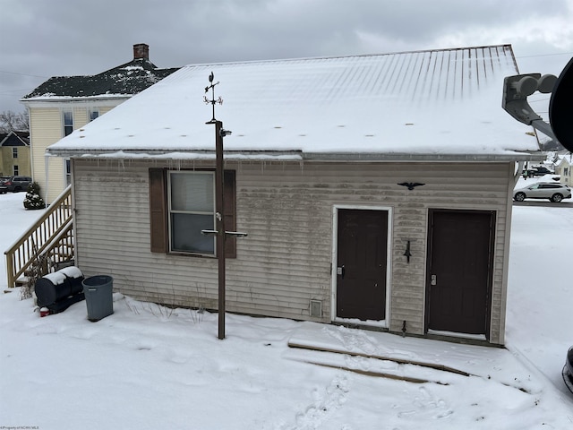 view of snow covered rear of property