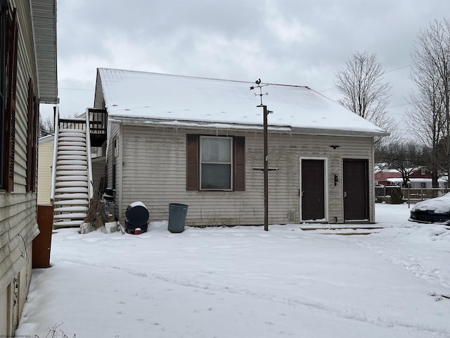 snow covered property featuring stairway