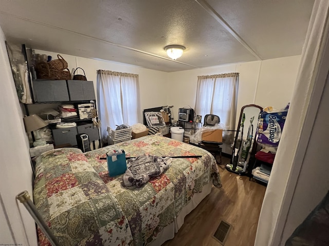 bedroom featuring a textured ceiling and wood finished floors