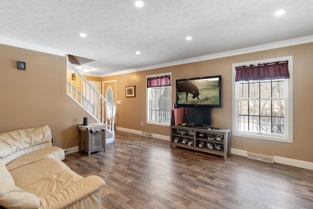 living room featuring dark wood finished floors, visible vents, stairway, ornamental molding, and a textured ceiling