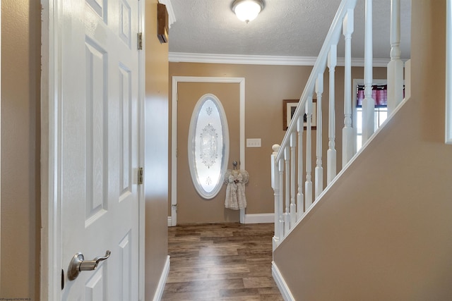 entryway featuring a textured ceiling, baseboards, ornamental molding, stairway, and dark wood finished floors