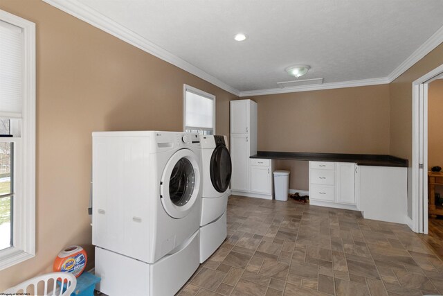 laundry room featuring ornamental molding, washing machine and dryer, and cabinet space